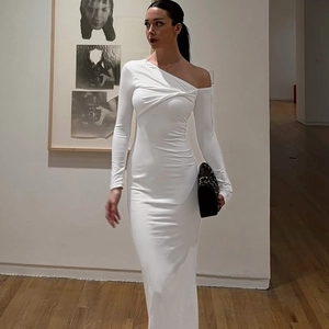 Détail d'une robe blanche à une épaule avec un élégant drapé noué et un tissu lisse et doux