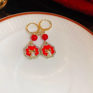 Detail of red dragon New Year earrings with gold finish, pearls and rhinestones