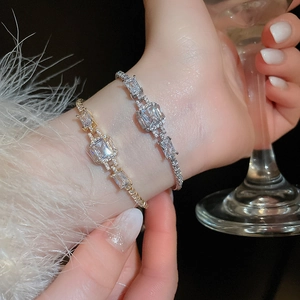 Close-up of luxury rectangular zircon interlocking bracelets in gold and silver finishes