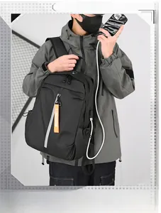 Detail of black laptop backpack showing external USB charging port and reflective strip