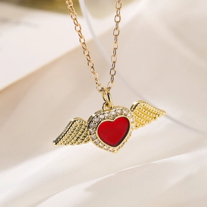 Elegant gold necklace with a red heart pendant and wings on white silk background
