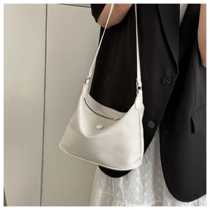 Mannequin portant un sac hobo demi-lune en nylon crème avec une bandoulière réglable