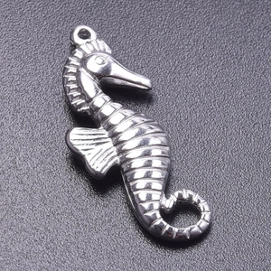 Close-up of a silver stainless steel seahorse pendant charm with intricate textures