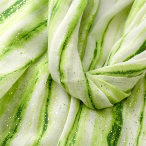 Macro shot of green and white striped cotton-linen scarf with elegant gold foil shimmer