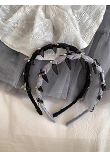 Detailed shot of ballet style bow headband with rhinestones and punk spikes on lace fabric