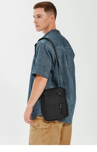 Detailed view of black waterproof oxford cloth crossbody bag on male model's shoulder