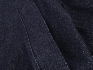 Makroaufnahme von dunkelblauem Denim-Stoff mit Fokus auf Köperbindung und Struktur