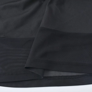 Gros plan sur le tissu en maille noire et les coutures de cet ensemble deux pièces