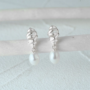 Detailed view of silver twist hoop earrings featuring elegant white teardrop pearls