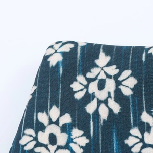 Close-up of indigo floral print fabric showing detailed fiber texture and rounded edges