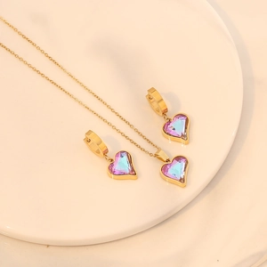 Elegant gold-tone heart necklace and earring set with faceted purple crystal stones