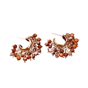 Retro gold C-shaped hoop earrings with brown and beige beaded pendants on white background