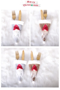 Close-up of grey and brown Gnome cutlery holders with gold silverware on festive table