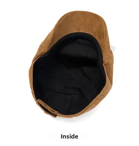 Detail view of brown faux suede flat cap showing interior fabric lining and metal buckle