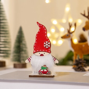 Detalle de gnomo navideño de madera con gorro rojo de copos y coche de juguete en base