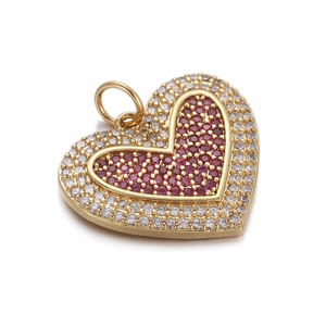 Detailed close-up of heart charm with gold plating and red crystal pavé setting