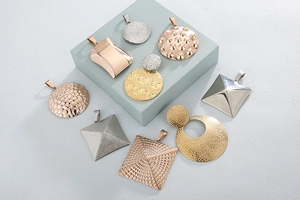 Detail showing geometric cube pendants and earrings in gold, silver and rose gold finishes