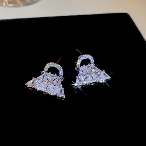 Dettaglio macro di orecchini a borsa in argento con pavé di zirconi su velluto nero