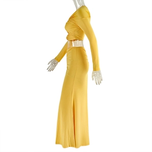 Detail side view of a ginger yellow two-piece set with long sleeve crop top and ruched skirt