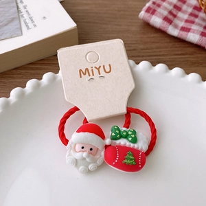 Close-up of Santa Claus and Christmas stocking hair ties on a decorative white plate