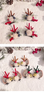 Detailed flat lay of reindeer antler hair clips with berries and pine on snowy background