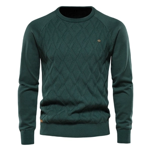 Detail of men's dark green knit sweater featuring textured diamond weave and raglan sleeves