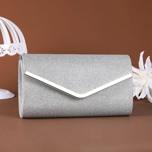 Detail of silver envelope clutch bag with glitter texture and metallic V-shaped trim edge