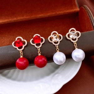 Detailed macro view of vintage floral drop earrings with zircons and pearls on a display
