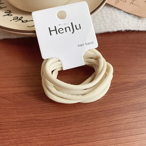 Detail of cream elastic hair ties set on display card with soft textured fabric finish