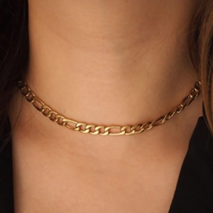 Gros plan d'un collier chaîne Figaro en acier inoxydable plaqué or 18 carats