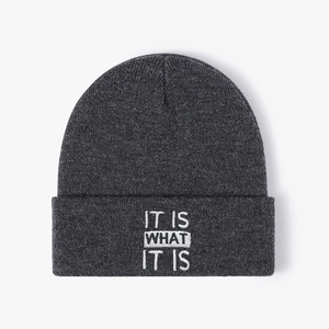 Dark grey knitted beanie featuring white IT IS WHAT IT IS embroidery for autumn winter
