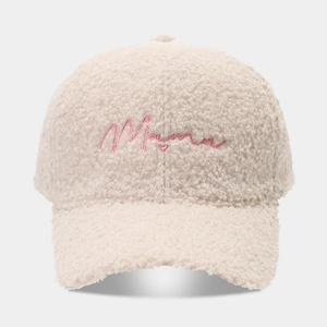 Dettaglio del cappellino in pile beige con ricamo Mama rosa e piccolo cuore decorativo