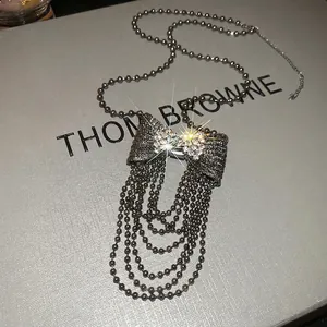 Sparkling rhinestone bow pendant necklace with multilayer ball chain tassels in gunmetal