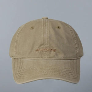 Close-up of embroidered NAGENARA lettering on a khaki cotton baseball cap with stitched brim
