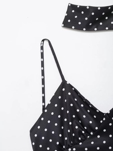 Detailansicht von schwarzem Polka-Dot-Stoff mit Halstuch und plissiertem Ausschnitt