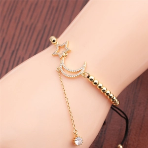 Close-up of gold moon and star bracelet with cubic zirconia on a model's hand