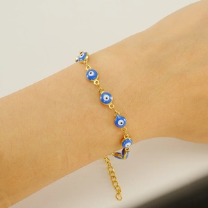 18K gold plated evil eye bracelet with blue enamel charms worn on a female wrist