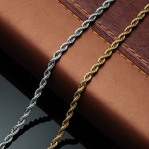Macro shot of silver and gold stainless steel rope chains on vintage leather background