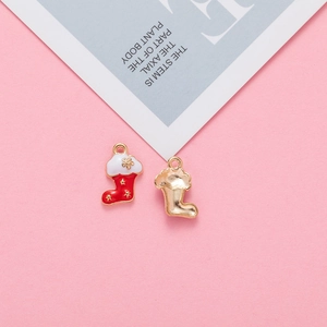 Detailed close-up of a red enamel Christmas stocking pendant with gold metal alloy edges