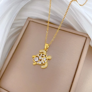 Detail of gold turtle pendant with shimmering crystals on an elegant gold chain