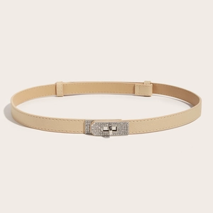 Close-up of adjustable narrow leather belt with sparkling rhinestone lock buckle and texture