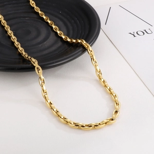 Close-up of high-polish gold anchor link chain necklace on elegant jewelry display