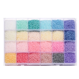 Flat lay of 24-compartment storage box with assorted colorful glass seed beads for DIY