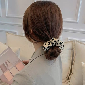 Chouchou élégant en tissu à motif vache porté en chignon bas pour un look coréen chic