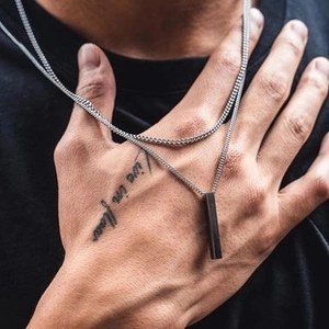 Close-up of minimalist rectangular bar pendant necklace on male model with industrial style