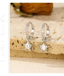 Detail of S925 sterling silver star drop earrings with moissanite on travertine stone
