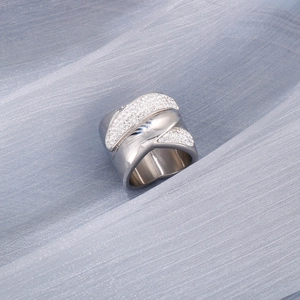 Macro view of silver stainless steel wide band ring with criss-cross pavé stones