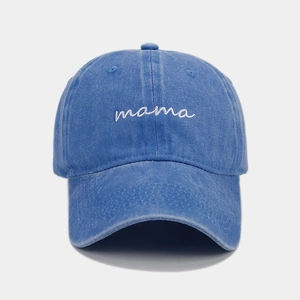 Close-up of white cursive mama embroidery on blue washed cotton baseball cap