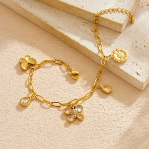 Gold plated stainless steel bracelet with butterfly, sunflower and teardrop stone pendants