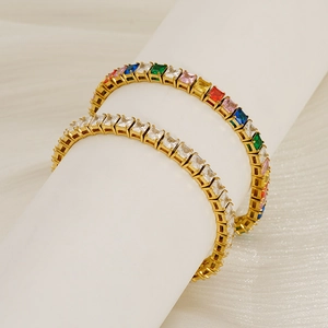 Macro view of gold tennis bracelets with square cut multicolored and white zircons